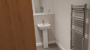 Un baño con lavamanos, espejo y barra para toallas.