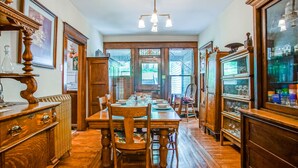 A dining area with a wooden table set for four, flanked by wooden cabinets and a large mirror. - 5 Br: Historic Glaab House in Cass, with AC, Amazing Kitchen, Covered Porches, Historical Landmark (Cass)