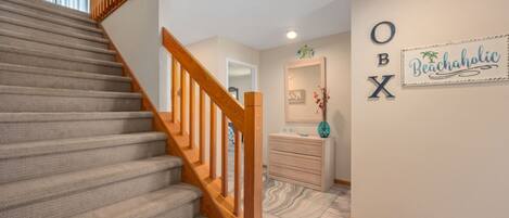 A staircase with a wooden handrail leading to a landing.