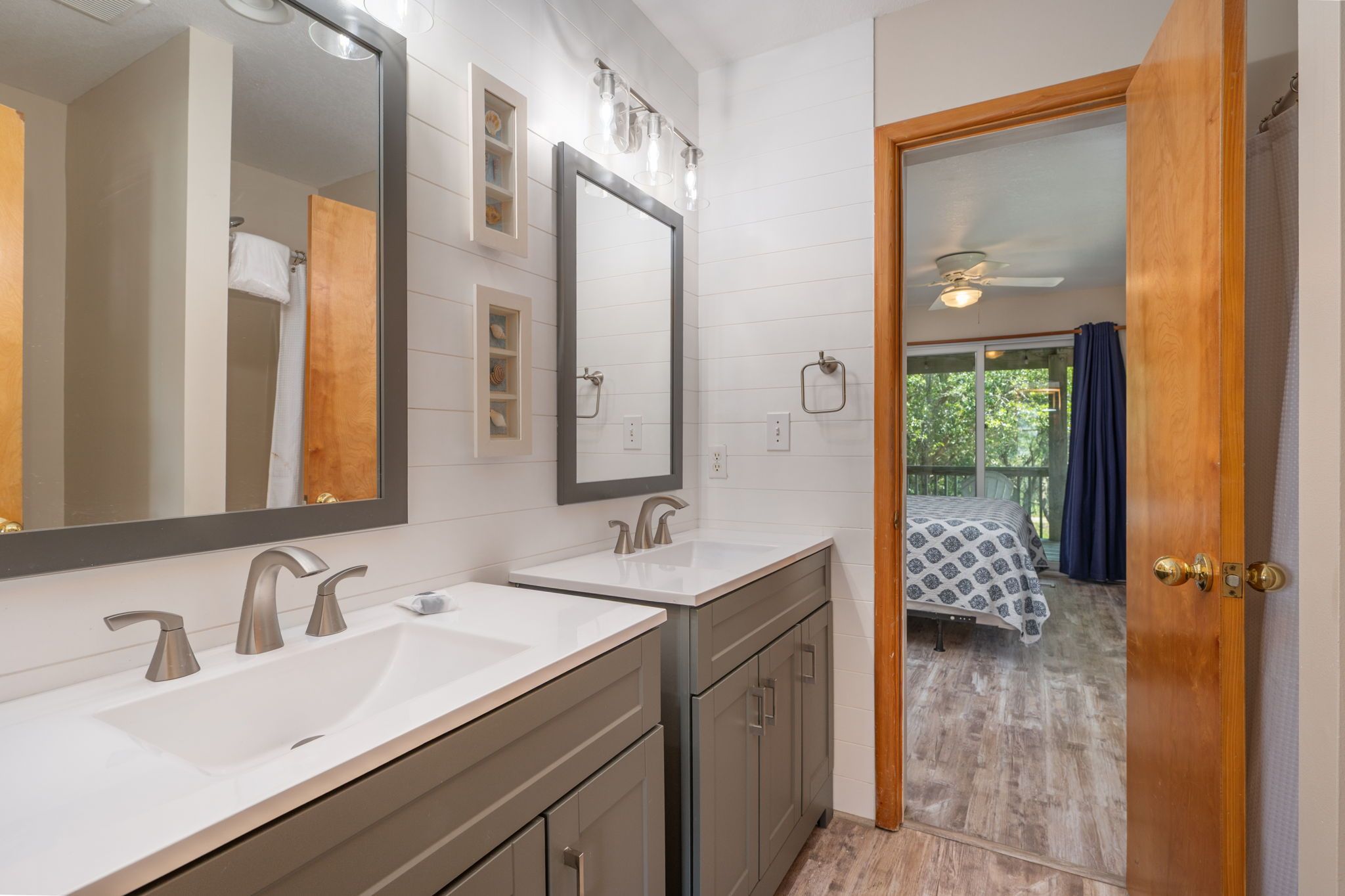 A bathroom with two sinks, a large mirror, and a shower.