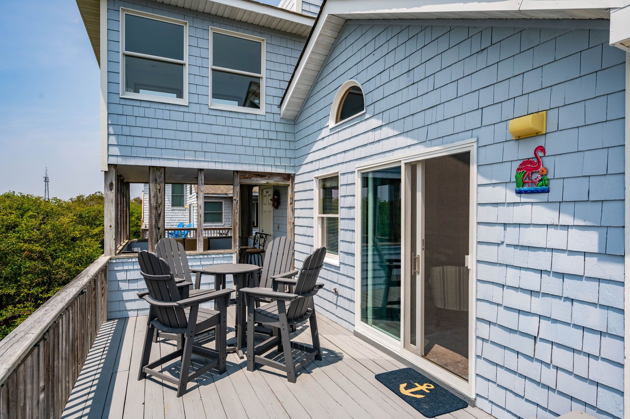 Een huis met een terras, buitenmeubels en een schuifpui.