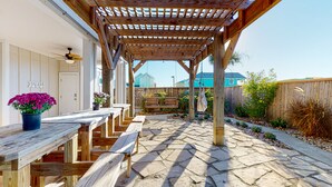 Un patio cubierto con bancos de madera y un camino de piedra.