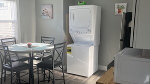 Cocina compacta con comedor, que incluye un microondas, un refrigerador y una mesa con sillas.