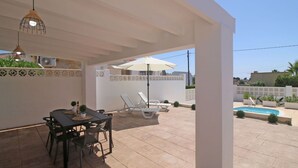 A covered patio with a table and chairs, a pool, and lounge chairs. - Wonderful private villa for 4 guests with A/C, WIFI, private pool, TV, patio and pets allowed (Benissa)