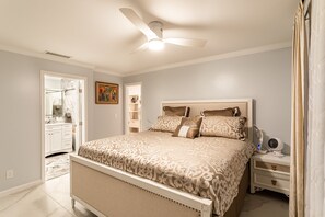 Quarto com cama, mesa de cabeceira e ventilador de teto.