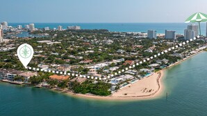 Luchtbeeld van een kustgebied met woonhuizen, een strand en een jachthaven.