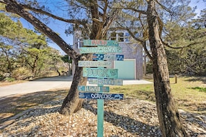 A signpost with multiple directional signs pointing to various locations with distances in miles.