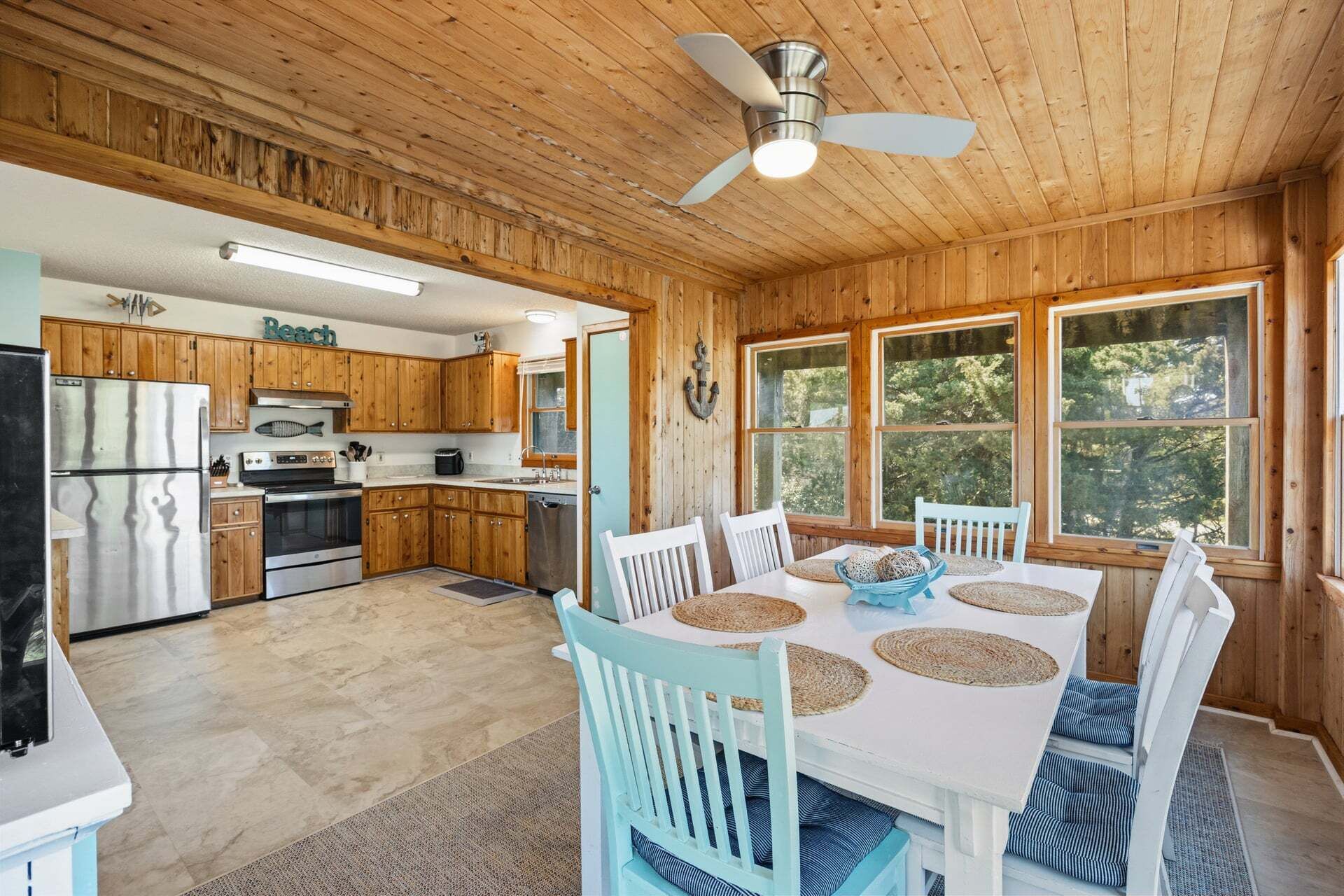 L’intérieur d’un chalet en bois comprend une cuisine, un coin repas et de grandes fenêtres.
