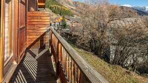 A wooden balcony with a view of a mountainous landscape and a village below. - Bright apt 4/6 ppl with balcony, near the ski runs (Saint-Sorlin-d´Arves)