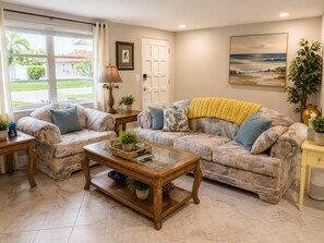 A living room with two sofas, a coffee table, and a painting on the wall. - Private Golden Beach access on Venice Island (Venice)
