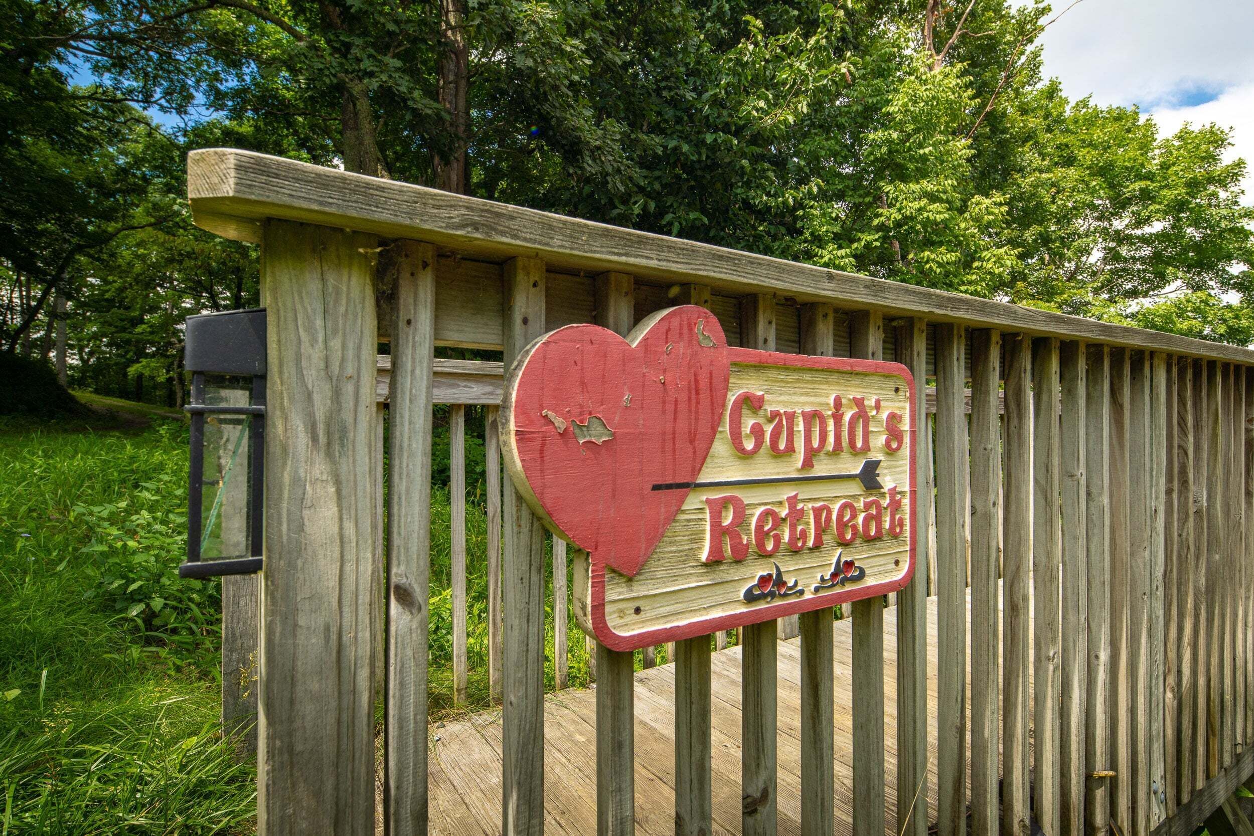 Una valla de madera con un letrero con forma de corazón que dice 'Captain's Retreat'.