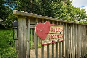 Une clôture en bois sur laquelle est fixée une plaque en forme de cœur portant l’inscription « Le refuge du capitaine ».