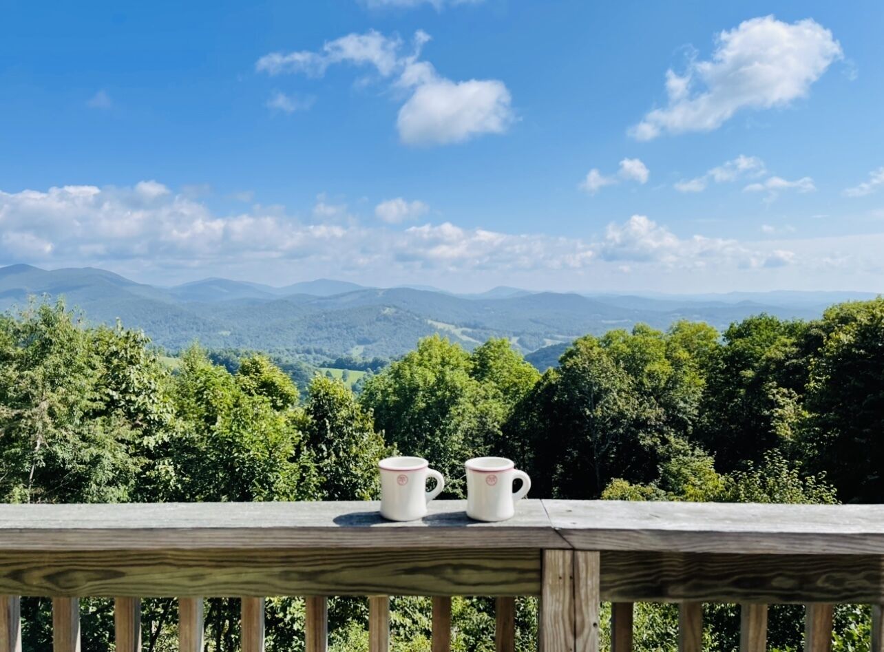 Un pont de fusta amb dues tasses de ceràmica blanca.