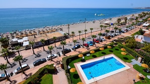 Ein Hotel an der Küste mit Pool, Zugang zum Strand und Parkplatz.