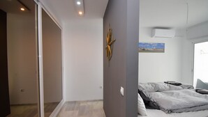 Una camera da letto con un letto, un condizionatore d'aria a parete e un quadro.