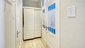 Ein schmaler Flur mit einer Schiebetür und einer Tür mit satinierten Glasfeldern.