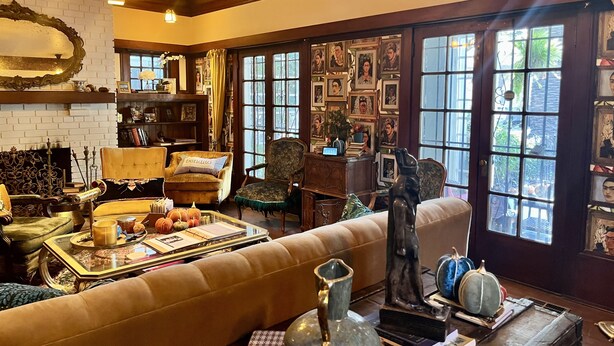 Una sala de estar acogedora con chimenea, una estantería y un ventanal con fotografías enmarcadas.