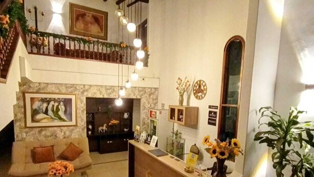 Amplia sala de estar con chimenea, un sofá, una mesita de centro y un mostrador de recepción.
