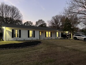 A single-story house with a front porch, a garage, and a driveway.