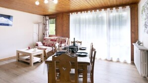 A dining area with wooden furniture, a table set for four, and a ceiling fan.