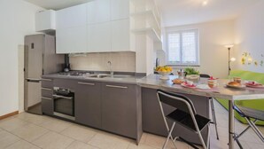 Een moderne keuken met een centraal eiland, een inbouwoven en een spoelbak.