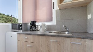 Uma cozinha moderna com micro-ondas embutido, cafeteira e pia.