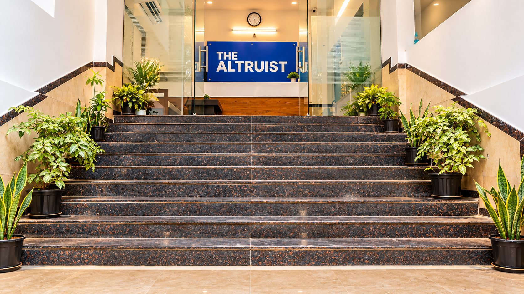 A set of marble stairs leading to a reception area with a sign reading 'THE ALTRUST'.