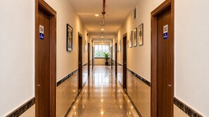 A hotel hallway with doors numbered 504 and 502, a potted plant, and framed artwork on the walls. - The Altruist Koparkhairane Hotel (Navi Mumbai)