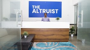 A reception desk with a sign reading "THE ALTRUIT" in a modern office setting. - The Altruist Koparkhairane Hotel (Navi Mumbai)