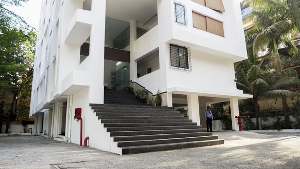 A multi-story building with a staircase leading to the entrance. - The Altruist Koparkhairane Hotel (Navi Mumbai)