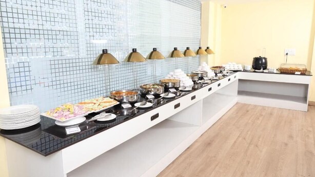 Una mesa de buffet con distintos alimentos y un revoque de azulejos.
