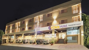 Un Click Hotel de diseño moderno, con varios pisos, estacionamiento techado y fachada bien iluminada.