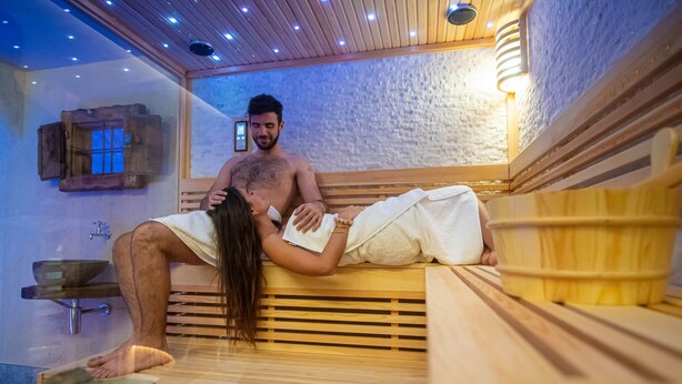 A sauna room with wooden benches, a wooden bench with a towel, and a wooden cabinet with a window. - 'Le Chalet Suite' with mountain view, private terrace and Wi-Fi (Livigno)