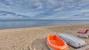 Ein Strand mit einem Ruderboot und einem Rettungsring im Sand.