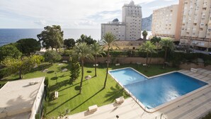 A hotel with a swimming pool, palm trees, and a view of the sea. - A102 CALPPLACE 2-5º-2 (Calpe)