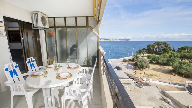 A balcony with a table set for dining, overlooking a beach and the sea. - A102 CALPPLACE 2-5º-2 (Calpe)