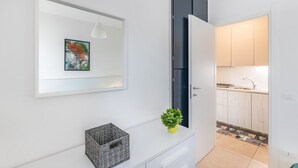 A modern kitchen with white cabinets, a black refrigerator, and a tiled backsplash. - Holiday Apartment "Casa Punta Grò" with Shared Pool, Terrace and Wi-Fi (Sirmione)