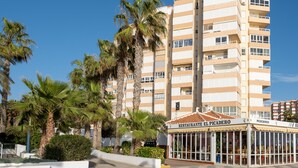 Um hotel com vários andares, varandas, um restaurante chamado 'RESTAURANTE EL PICADERO' e palmeiras em primeiro plano.