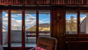 A wooden interior with a view of mountains through glass doors. - Appartement LaForet 23 - La Tzoumaz, 4 Vallees (La Tzoumaz)