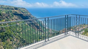 A balcony with a metal railing overlooking a coastal landscape with greenery and a view of the sea. - Holiday Home "Villa Camacho xxvii" with Sea View, Pool & Wi-Fi (Arco da Calheta)