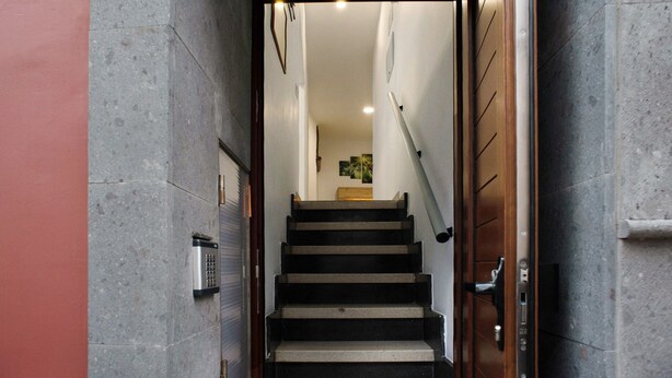 A staircase leading to an upper floor, with a door on the right and a wall-mounted intercom on the left. - Vacation 'Jardin Cardona' with Wi-Fi (Arucas)
