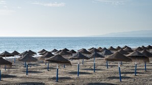 A beach with rows of thatched umbrellas and a clear view of the sea. - Apartment "Vistas Playa Torrox A73" with Sea View, Shared Pool and Wi-Fi (Torrox)