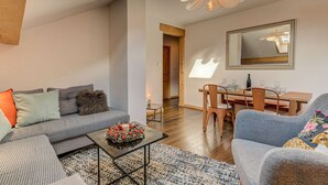 Una sala de estar moderna con un sofá, una mesa de centro y un comedor con sillas y una mesa.