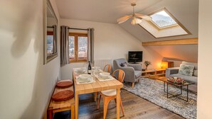 Un acogedor loft con comedor, sofá y televisor.