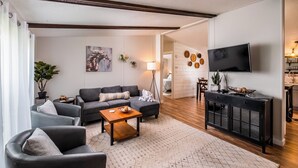 A modern living room with a sofa, armchairs, a coffee table, and a TV. - Escape to a beautiful country getaway (Philomath)