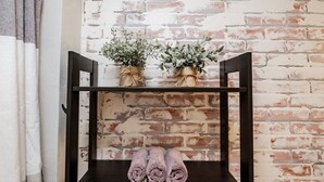 A shelf with two potted plants and three rolled towels against a brick wall. - Escape to a beautiful country getaway (Philomath)