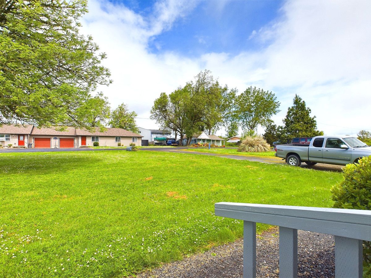 A residential area with houses, a grassy lawn, and a parked truck.