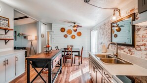A kitchen with a wooden table, chairs, a sink, and a ceiling fan. - Escape to a beautiful country getaway (Philomath)