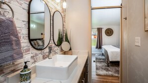 A bathroom with a white sink, two mirrors, and a brick wall. - Escape to a beautiful country getaway (Philomath)
