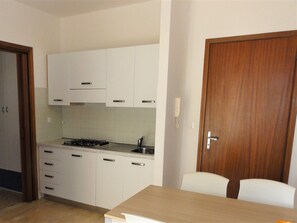 Kühlschrank, Herdplatte, Kochgeschirr/Geschirr/Besteck, Esstisch